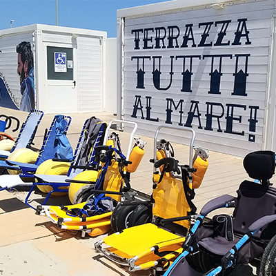 Beach wheelchairs lined up on a wooden deck at an accessible beach